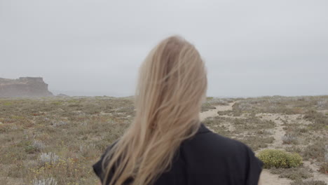 woman looking at the ocean on a foggy coast