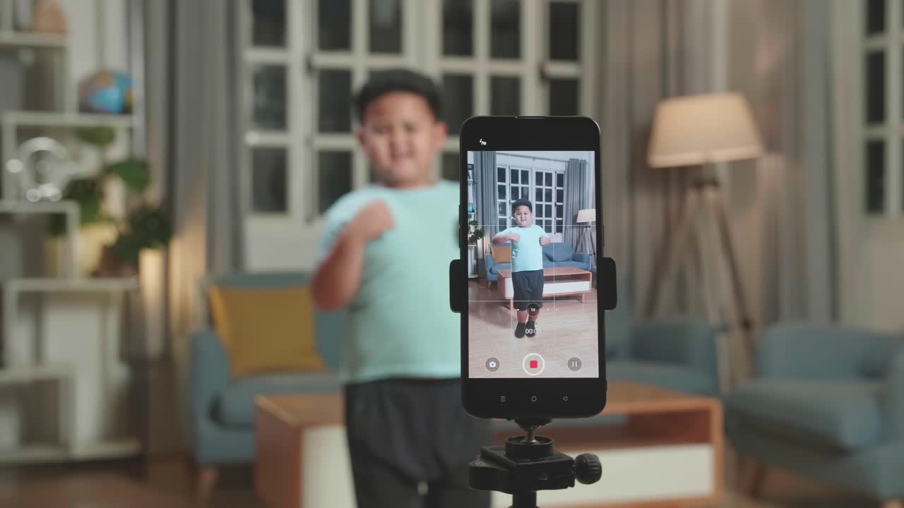 Display Smartphone Of Asian Little Boy Dancing While Shooting Video Content For Social Networks