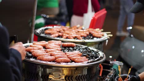 vendor grilling and serving sausages at a stall