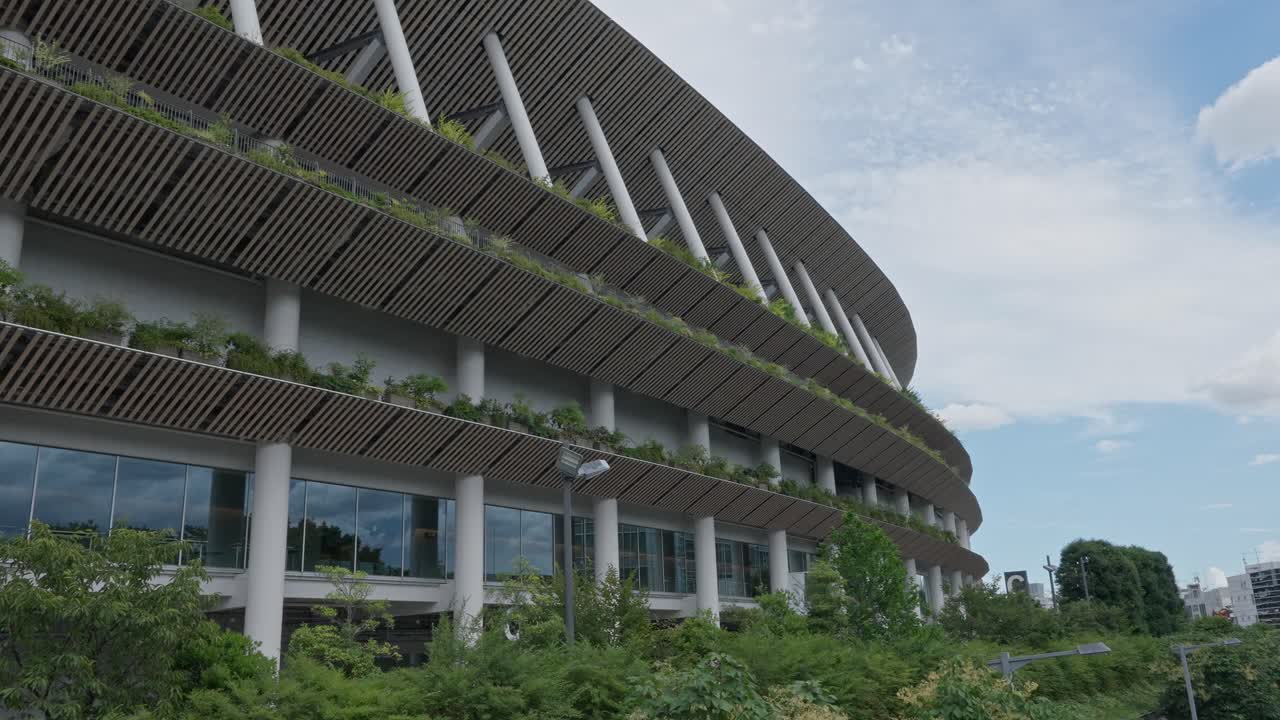 A detailed shot of the National Stadium, highlighting its modern architecture with a slatted wooden facade and green roof