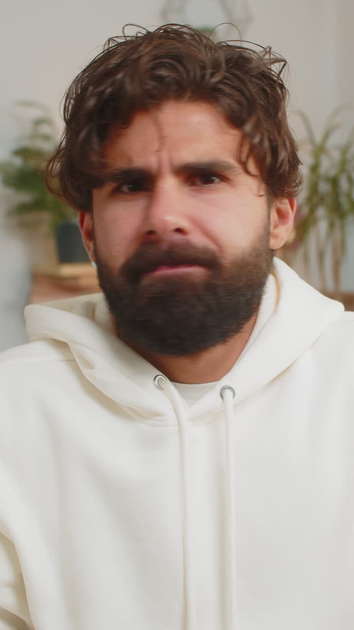 Portrait of upset indian young man making face disappointed in result bad news sitting on sofa