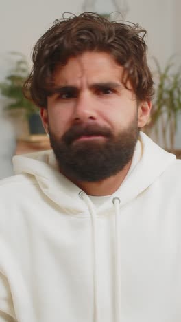 portrait of upset indian young man making face disappointed in result bad news sitting on sofa