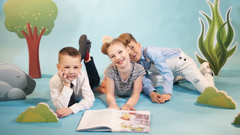 little children reading story books. studio shot of young cute children against background