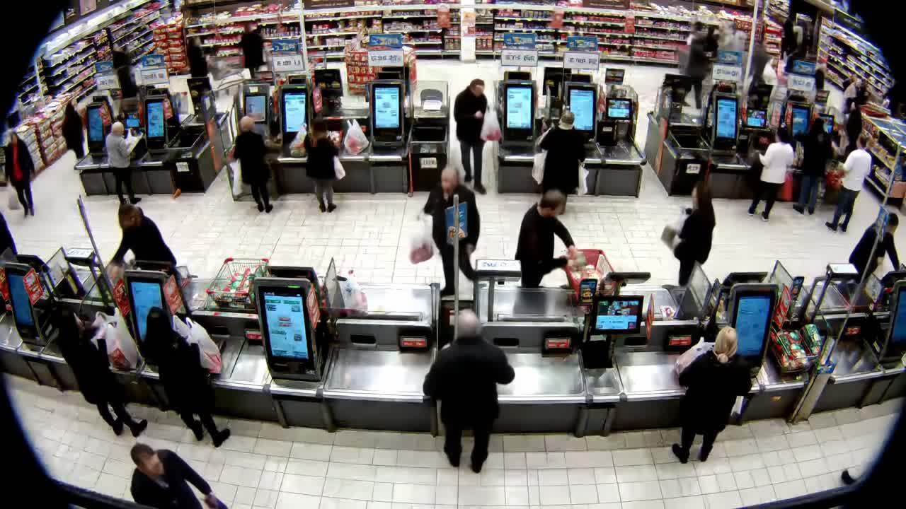 Busy Grocery Checkout Scene: Customers Engaged in Shopping and Scanning at Multiple Checkout Stations in a Well-Stocked Retail Environment