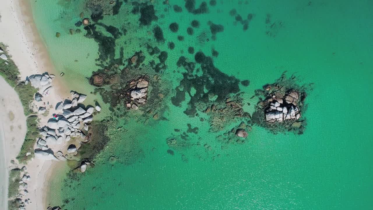 Aerial top down view of huge rocks in the sea, turquoise water and the beach. Beautiful seascape.