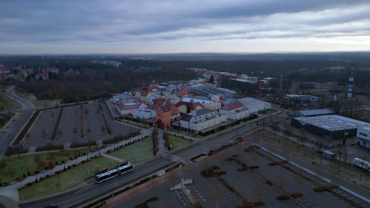 Veduta con drone che mostra un grande parco commerciale con vari edifici commerciali e un cancello d'ingresso principale durante l'inverno. Splendida vista aerea, panorama statico da drone in volo stazionario.