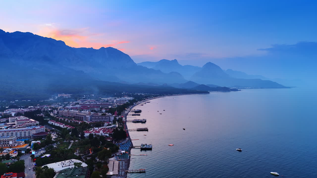Resort with multiple hotels, modern beaches and berths. Flight over the Mediterranean of Turkey at dusk time