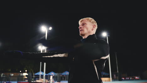 Sportive-Blond-Man-Doing-Stretching-Exercises-Before-Training-In-The-Park-At-Night-5