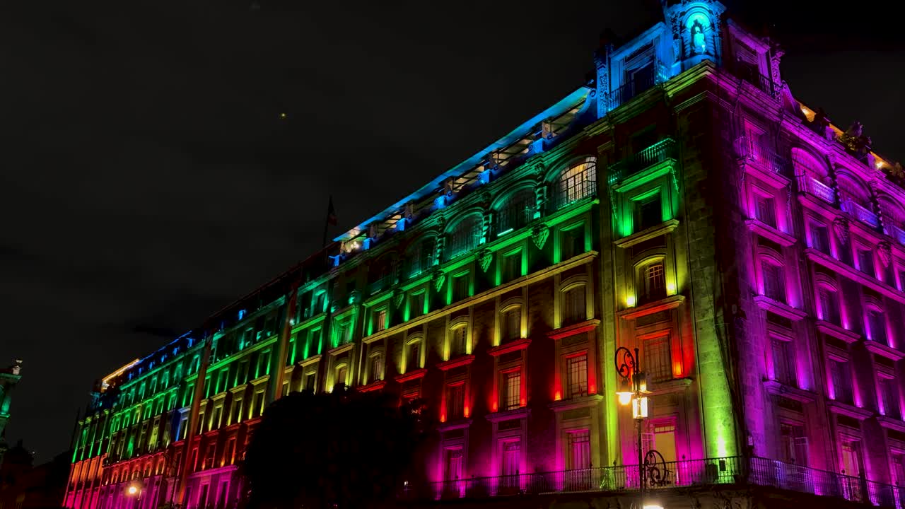 Large building lit in lgbt pride rainbow colors