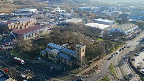 cinematic aerial drone footage of a old industrial town in yorkshire england showing church industrial estate, and busy town with traffic and roads