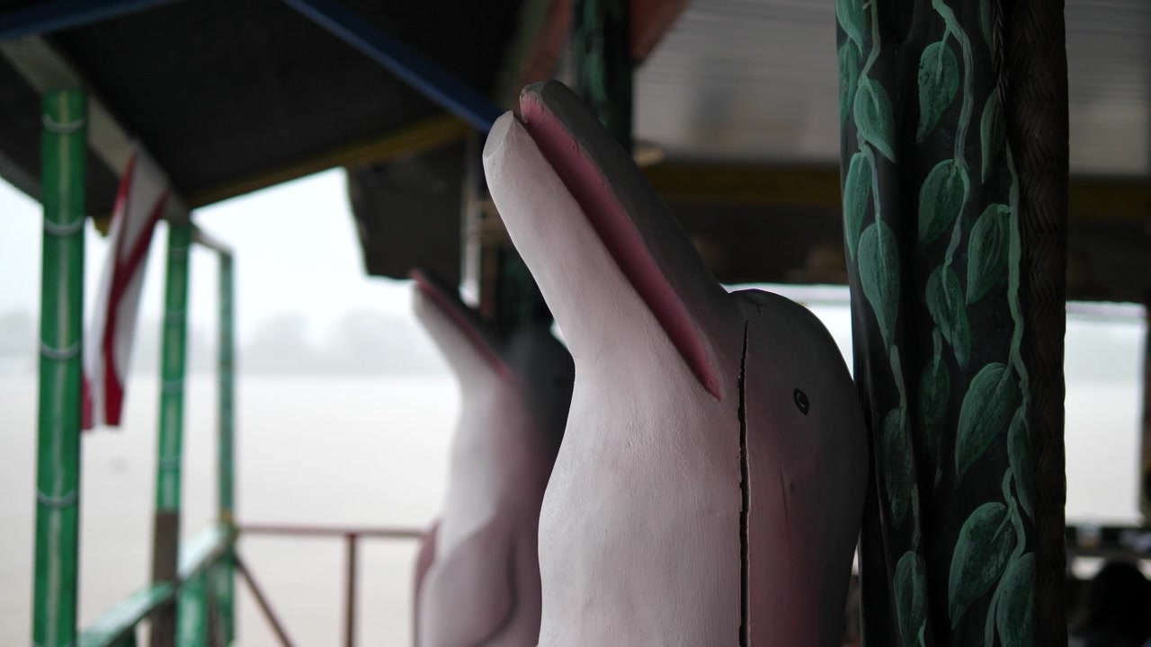 Una statua di delfino in legno crepato nella capanna