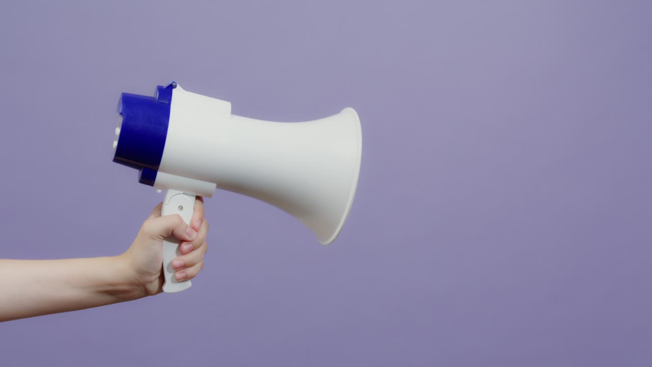 색과 파란색의 메가폰을 들고 있는 손