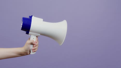 hand holding a white and blue megaphone