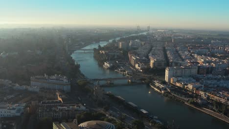 Puente-de-San-Telmo-Aerial-Drone-View-Over-Guadalquivir-River-With-Torre-del-Oro-In-Seville,-Spain