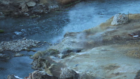 hot steam along water stream at hot creek geological site, inyo national forest, slow motion, high angle