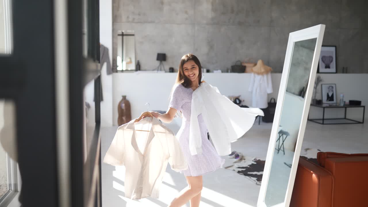 una mujer joven probando ropa en un elegante apartamento.