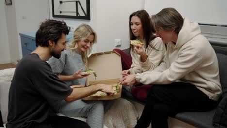 cita doble. amigos felices masculinos y femeninos tomando una deliciosa pizza en el interior de la casa