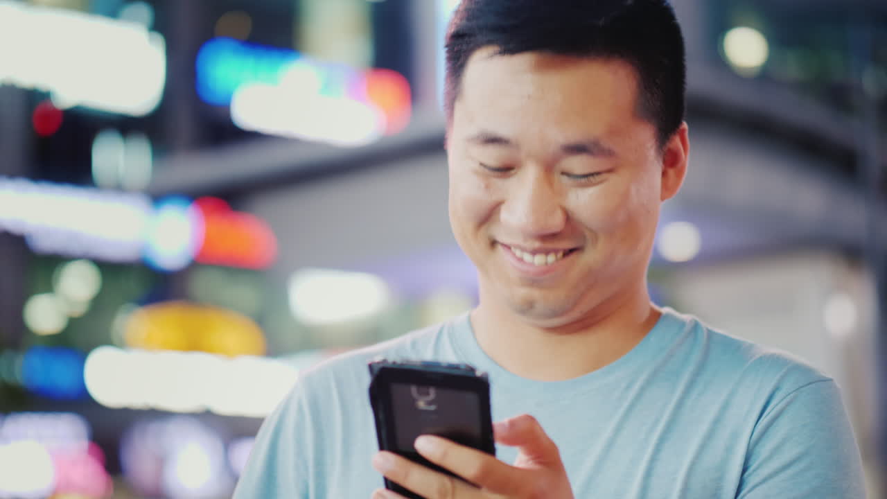 밤에 도시에서 전화를 사용하는 남자