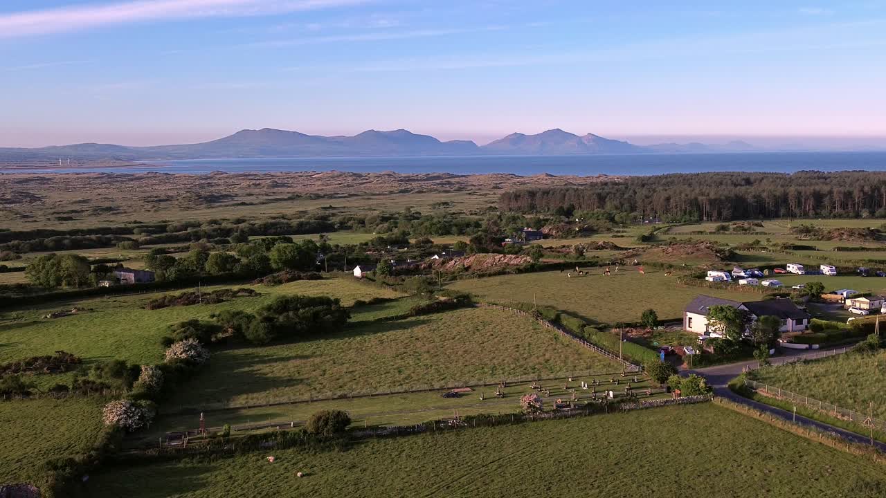 Idyllic Welsh meadow under Snowdonia mountains aerial descending view over rural Eryri national park
