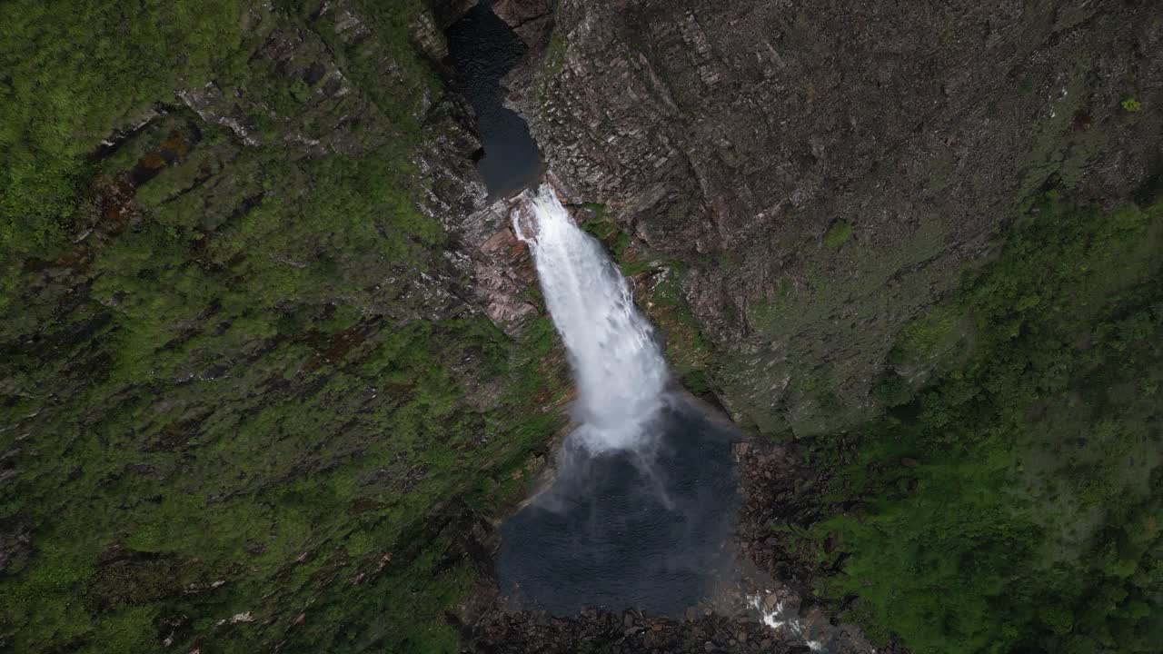 Rotating aerial descends toward tall Casca D'anta waterfall in Brazil