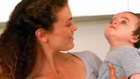 mother holding her baby son in the kitchen
