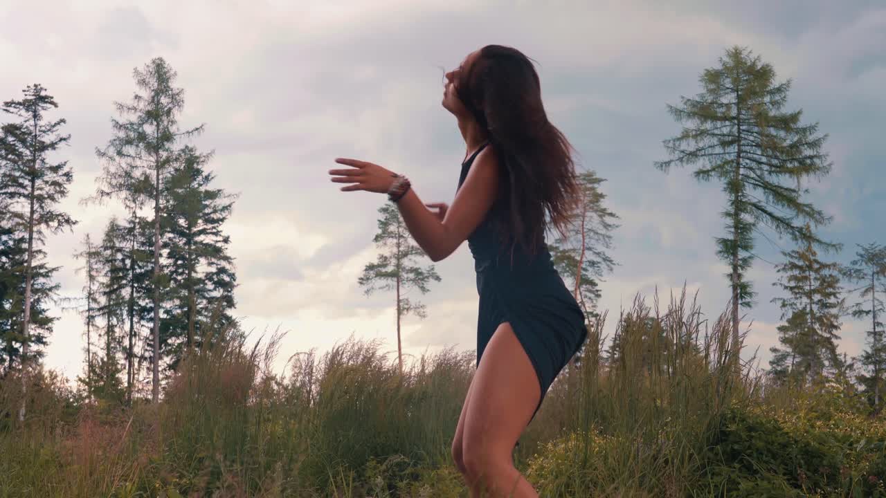 espectacular puesta de sol en el bosque con un buen flujo de baile femenino asiático entre la naturaleza alrededor de árboles altos y hierba