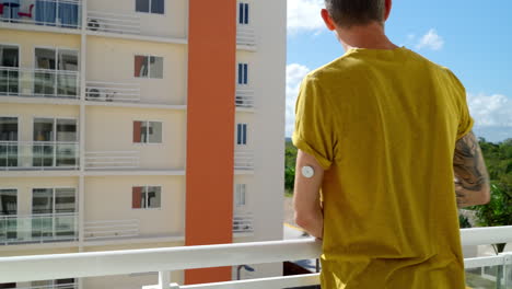 Young-Adult-Male-Checking-His-Blood-Glucose-Levels-On-Left-Arm-With-Freestyle-Libre-2-Sensor-By-Hotel-Balcony