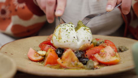 fresh burrata cheese on a bed of seasoned tomatoes