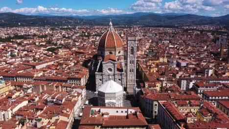 Aerial-view-of-Cathedral-of-Santa-Maria-del-Fiore-zooming-out-with-city-and-mounatins-on-a-sunny-day-in-Florence-in-Italy-in-4k