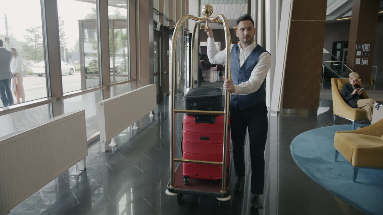 Hotel Bellhop Carrying Luggage in Lobby