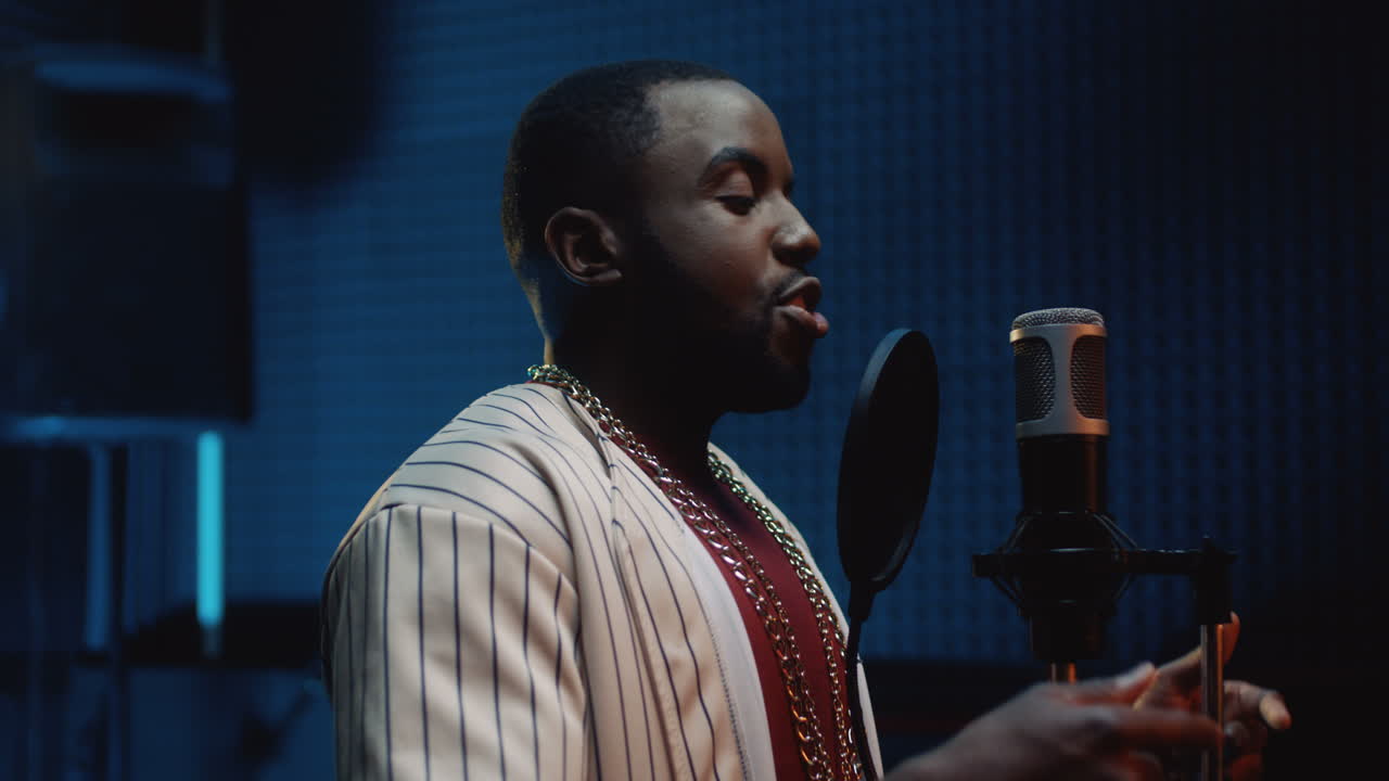 elegante joven cantante cantando en el micrófono en el estudio de sonido mientras graba su nueva canción 1