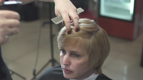 giovane donna che si veste i capelli nel parrucchiere 1