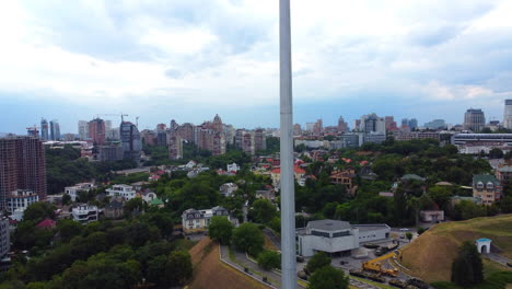 camera rising along the pole to reveal a huge ukrainian flag at the peak, located in the center of kyiv near motherland monument