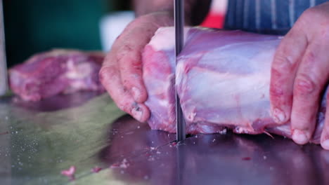 Vista-De-Cerca-Del-Carnicero-Caucásico-Usando-Una-Sierra-De-Cinta-Para-Cortar-Carne-De-Venado