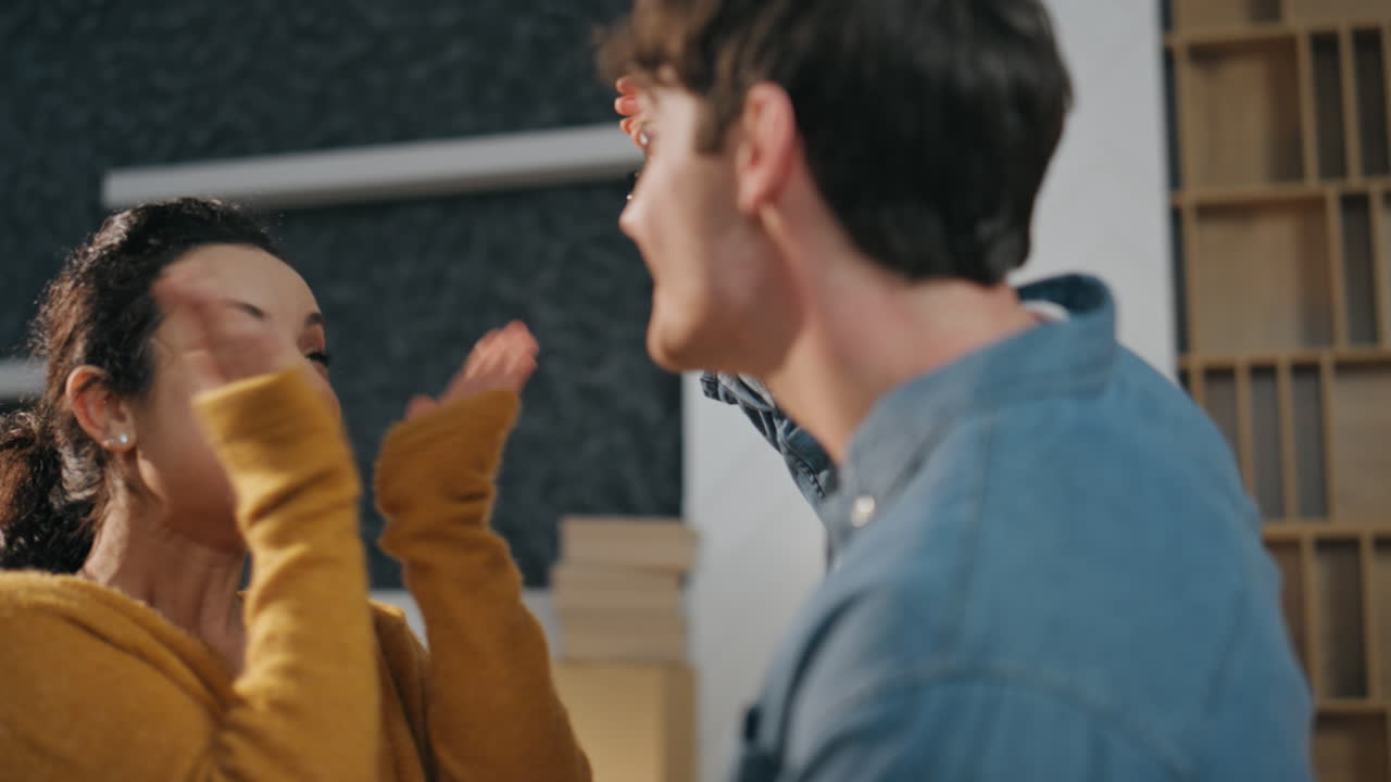 아내가 새 집을 기하며, 손을 치며, 남편을 안고, 가까이에서 가족이 이사합니다.