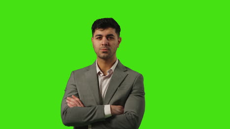 Porträt-Eines-Jungen-Geschäftsmannes,-Der-Vor-Einem-Greenscreen-Steht-Und-Die-Arme-Vor-Einem-Greenscreen-Hintergrund-Verschränkt