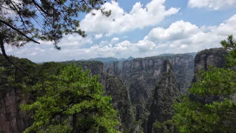 camera pans right across dramatic forested cliffs and sandstone towers in zhangjiajie, china