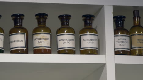 close up shot of toxic chemicals preserved in retro brown bottles standing in cupboard