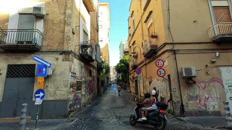 moped travels through narrow alley in naples