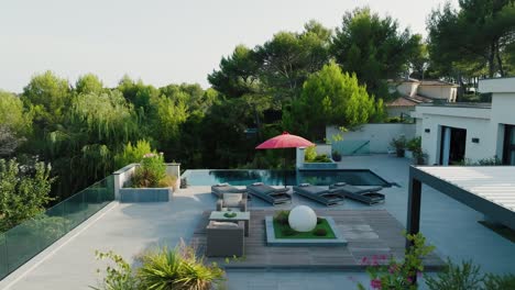 chic villa poolside lounging area in southern france, aerial flyover