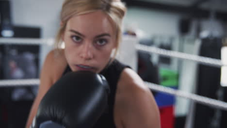 point of view shot of female boxing coach in gym sparring in boxing ring