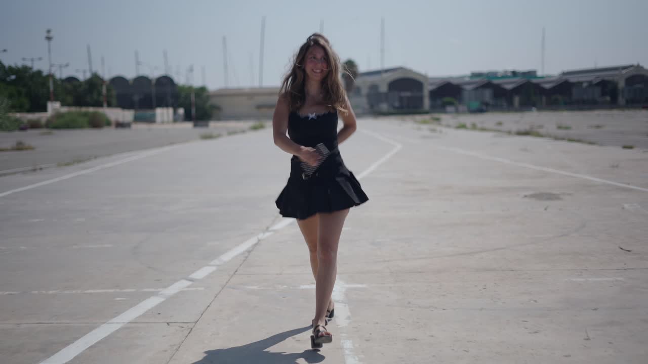 Giovane donna che cammina su una strada vuota