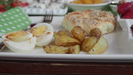 buffet de desayuno con huevos, patatas, pan y frutas