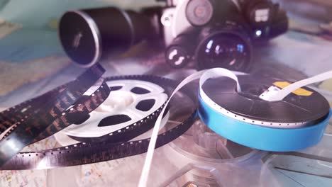 vintage analog cine camera and film reels laid out on retro travel map
