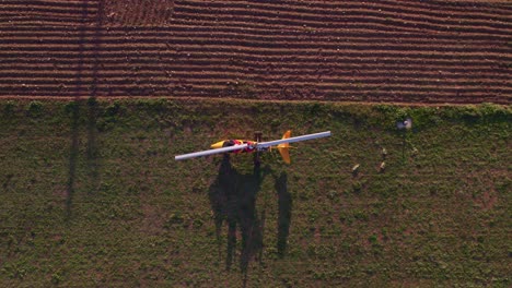 Oben-Stationärer-Gelber-Gyrocopter-Mit-Weißem-Blatt-Im-Ländlichen-Bereich,-Von-Oben-Nach-Unten