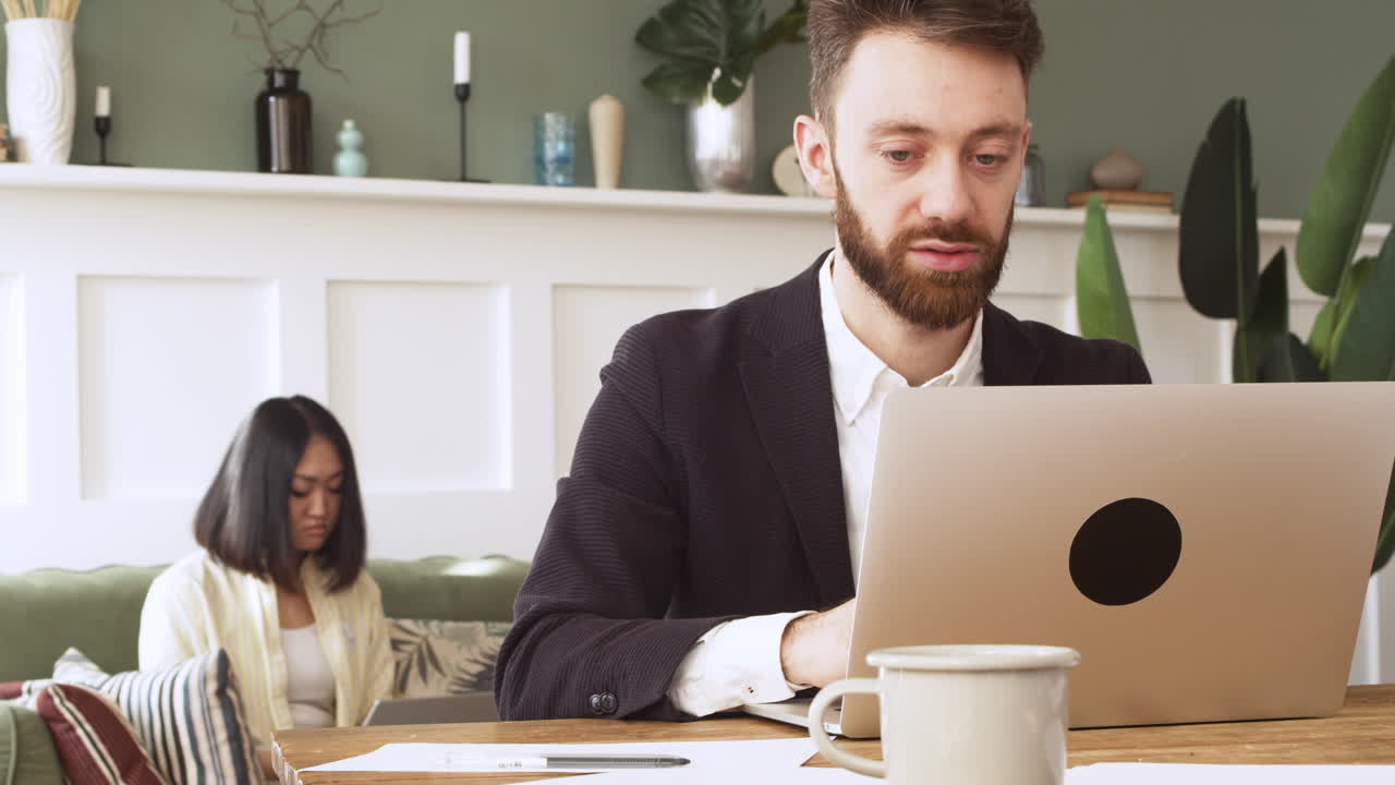 Businessman Sitting At Table And Working On Laptop Computer