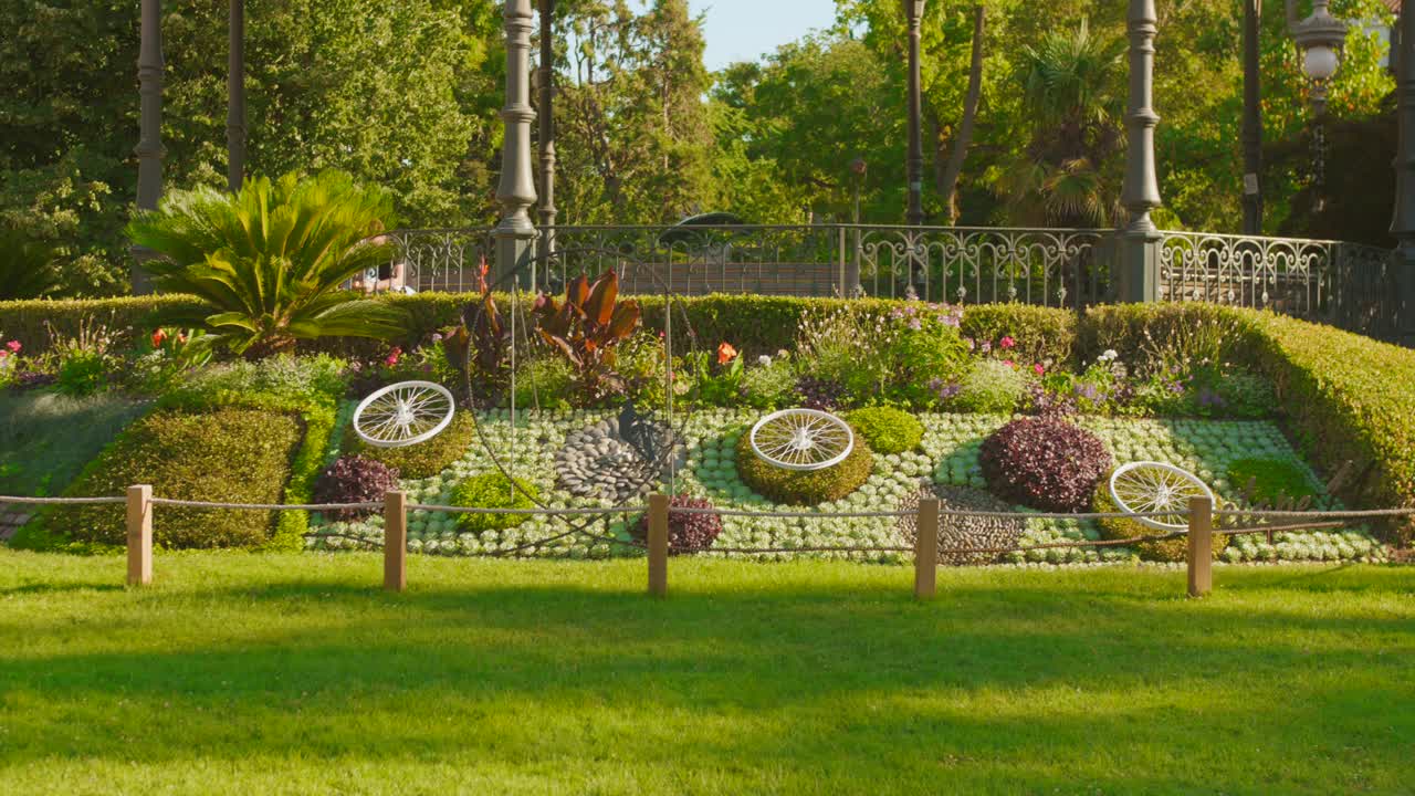 Vista aerea del parco Grand Rond a Tolosa, con ruote di bicicletta decorative per il Tour de France. Giornata di sole.