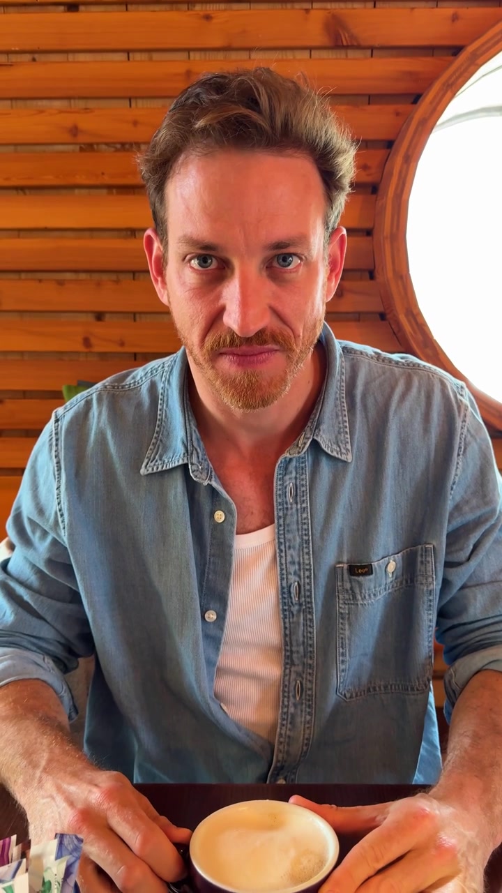 Young man disgust after tasting a cup of coffee, making a grimacing facial expression as he pulls away from the drink. Casual indoor setting with natural lighting. coffee place, cappuccino. drink