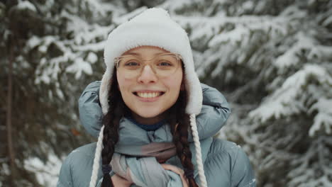 portrait of cheerful woman in forest on winter day