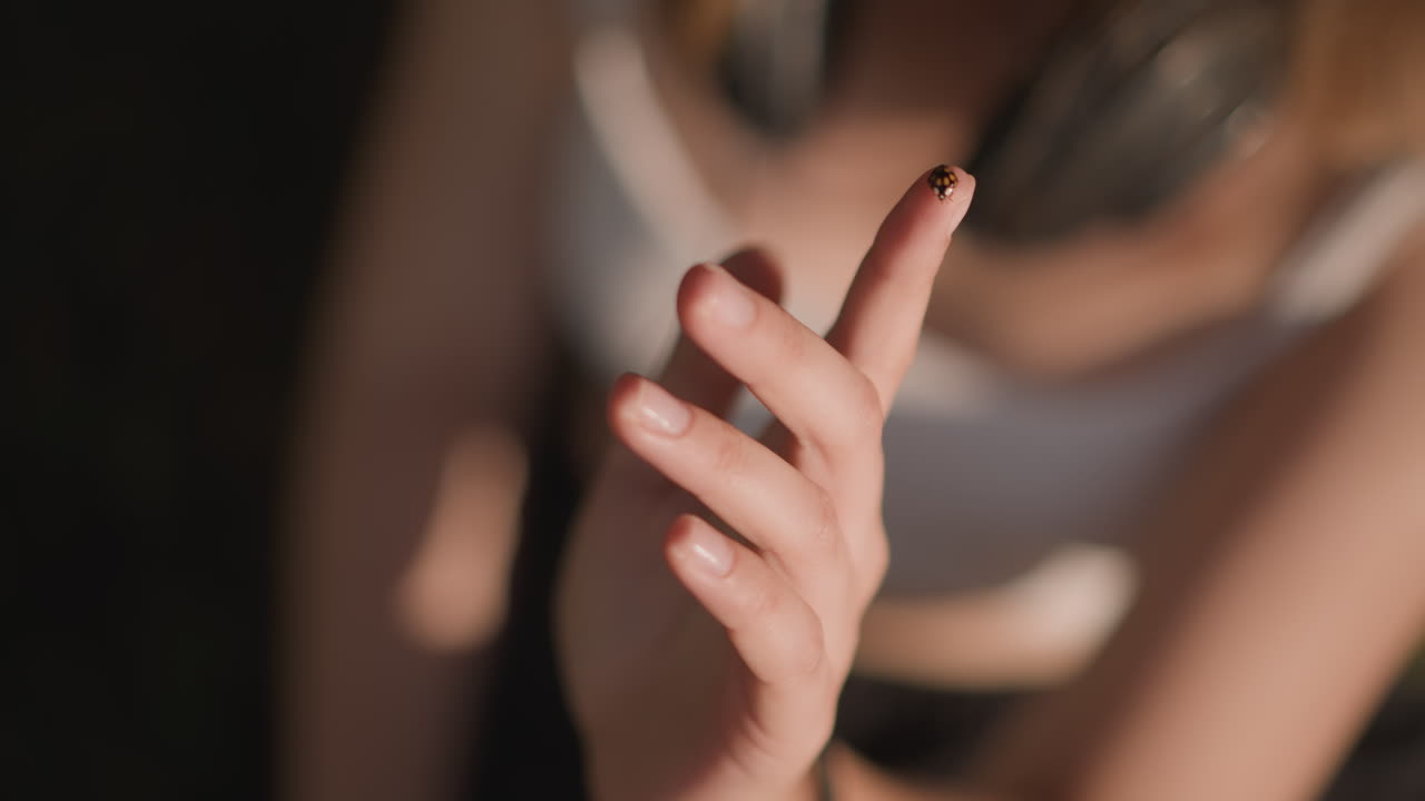 closeup hands with ladybug on fingertip, intimate outdoor study of gentle finger choreography and warm sunlight on skin, subtle movement suggesting dancer practicing delicate gestures, soft bokeh